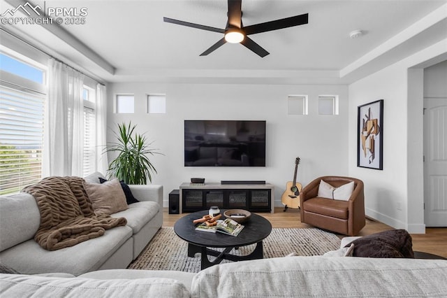 8257 Plumwood Cir, Colorado Springs, CO 80927 - living room featuring a tray ceiling, ceiling fan, wood finished floors, and baseboards