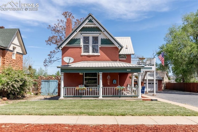 521 W Corona Ave, Pueblo, CO 81004 - view of front of home featuring covered porch, brick siding, metal roof, a chimney, and a garage