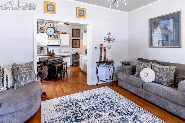 521 W Corona Ave, Pueblo, CO 81004 - living area with ornamental molding, wood finished floors, baseboards, and a chandelier