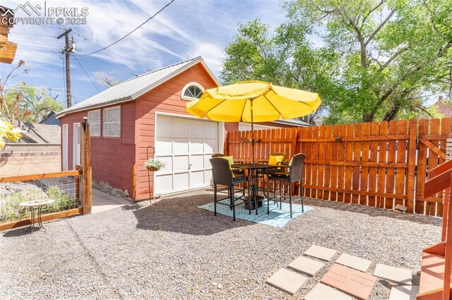 521 W Corona Ave, Pueblo, CO 81004 - view of patio featuring fence, an outdoor structure, and a detached garage