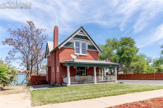 521 W Corona Ave, Pueblo, CO 81004 - victorian home with covered porch, a chimney, brick siding, and metal roof