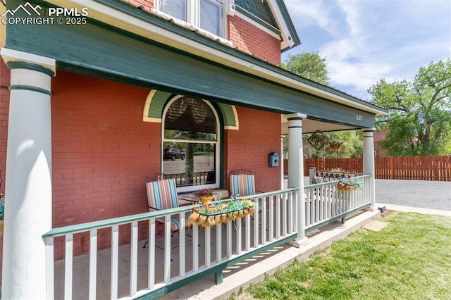 521 W Corona Ave, Pueblo, CO 81004 - doorway to property featuring a porch, brick siding, and fence