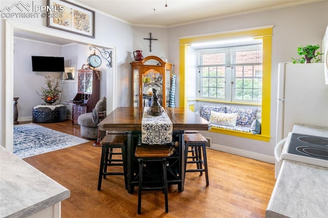 521 W Corona Ave, Pueblo, CO 81004 - dining space featuring light wood-style flooring, ornamental molding, and baseboards
