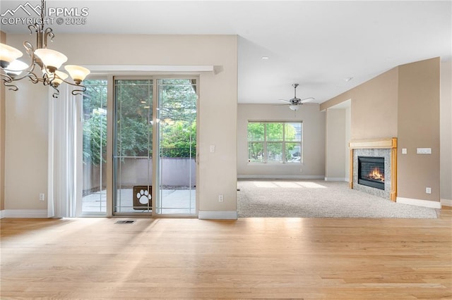 1076 Rosemary St, Denver, CO 80230 - unfurnished living room with wood finished floors, baseboards, a tiled fireplace, and a chandelier