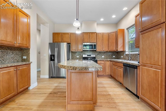 1076 Rosemary St, Denver, CO 80230 - kitchen featuring stainless steel appliances, a sink, a kitchen island, light wood-style floors, and tile counters