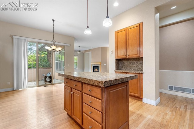 1076 Rosemary St, Denver, CO 80230 - kitchen with light wood finished floors, backsplash, a center island, brown cabinets, and recessed lighting