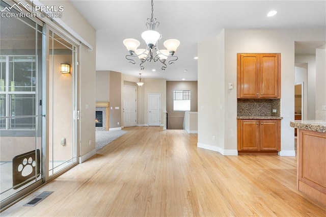 1076 Rosemary St, Denver, CO 80230 - unfurnished dining area featuring light wood-type flooring, a chandelier, baseboards, recessed lighting, and a glass covered fireplace