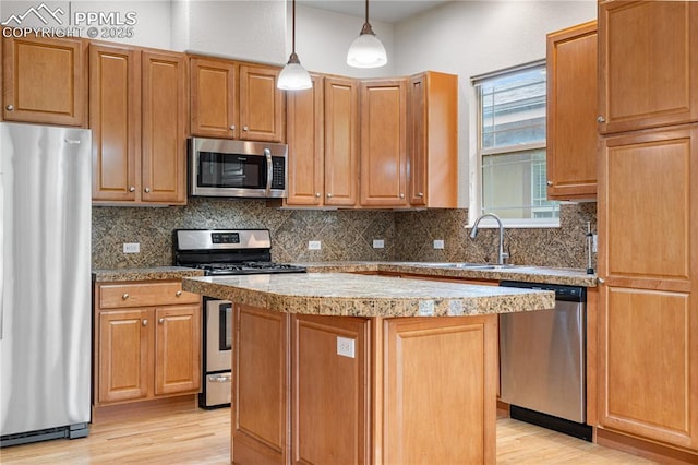 1076 Rosemary St, Denver, CO 80230 - kitchen featuring appliances with stainless steel finishes, light wood-style floors, a kitchen island, and tasteful backsplash