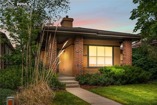 1076 Rosemary St, Denver, CO 80230 - view of front of property featuring brick siding and a lawn