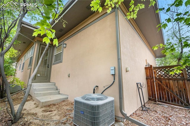 1076 Rosemary St, Denver, CO 80230 - view of side of home featuring entry steps, central AC unit, and stucco siding