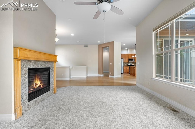 1076 Rosemary St, Denver, CO 80230 - unfurnished living room with light carpet, a tiled fireplace, a ceiling fan, baseboards, and recessed lighting