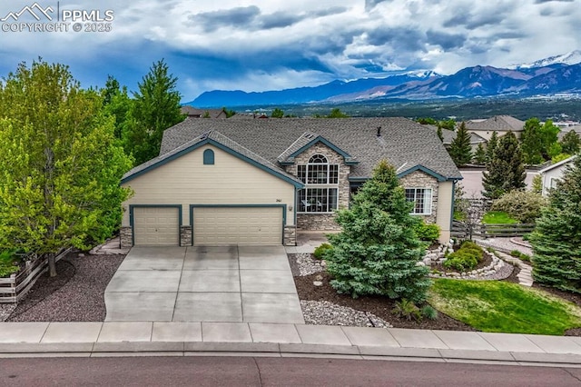 261 Saber Creek Dr, Monument, CO 80132 - view of front facade with a mountain view, stone siding, an attached garage, and driveway