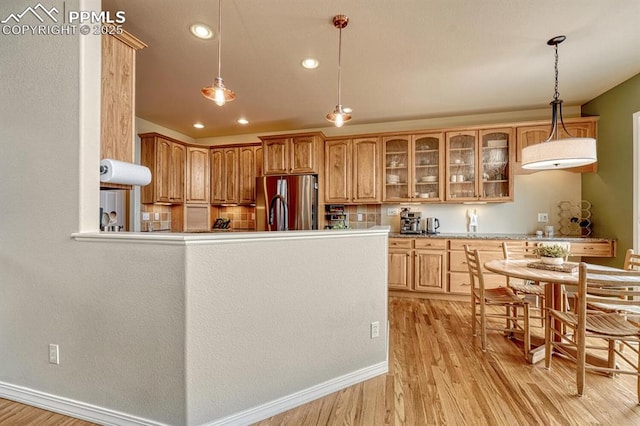 261 Saber Creek Dr, Monument, CO 80132 - kitchen featuring freestanding refrigerator, light wood-style flooring, glass insert cabinets, recessed lighting, and decorative light fixtures