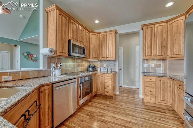 261 Saber Creek Dr, Monument, CO 80132 - kitchen with stainless steel appliances, light wood-style flooring, light stone countertops, tasteful backsplash, and recessed lighting