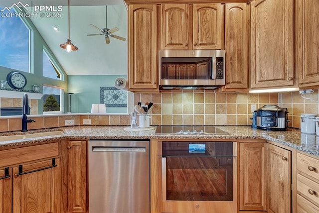261 Saber Creek Dr, Monument, CO 80132 - kitchen featuring black appliances, a sink, tasteful backsplash, light stone countertops, and vaulted ceiling