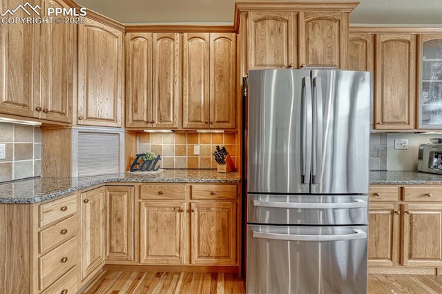 261 Saber Creek Dr, Monument, CO 80132 - kitchen featuring freestanding refrigerator, light stone countertops, and decorative backsplash