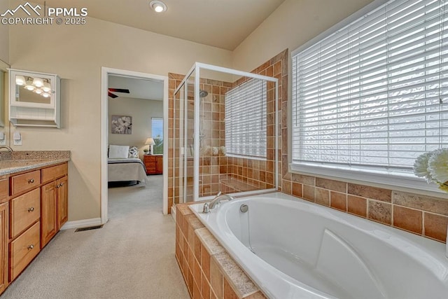 261 Saber Creek Dr, Monument, CO 80132 - ensuite bathroom with vanity, a bath, tiled shower, and baseboards