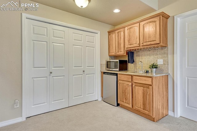 261 Saber Creek Dr, Monument, CO 80132 - kitchen featuring appliances with stainless steel finishes, light colored carpet, a sink, light countertops, and recessed lighting