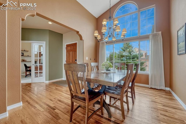 261 Saber Creek Dr, Monument, CO 80132 - dining room featuring light wood-type flooring, a chandelier, baseboards, and high vaulted ceiling