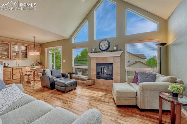 261 Saber Creek Dr, Monument, CO 80132 - living room featuring light wood-type flooring, high vaulted ceiling, and a tile fireplace