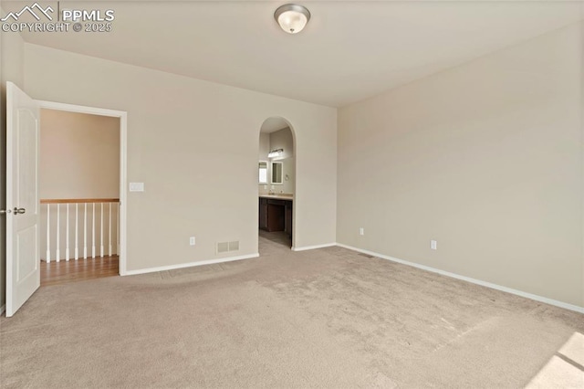 7031 Thorn Brush Way, Colorado Springs, CO 80923 - empty room with light colored carpet, arched walkways, and baseboards