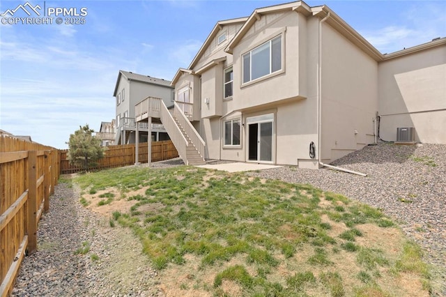 7031 Thorn Brush Way, Colorado Springs, CO 80923 - rear view of property featuring stucco siding, central AC unit, stairway, and a patio