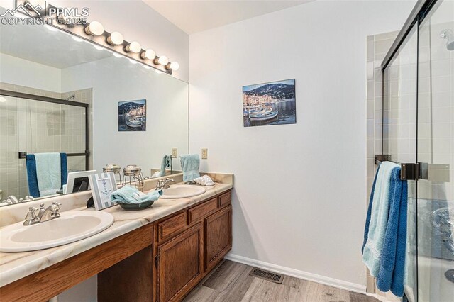 480 W Rockrimmon Blvd Unit D, Colorado Springs, CO 80919 - full bathroom with a shower stall, wood finished floors, double vanity, and baseboards