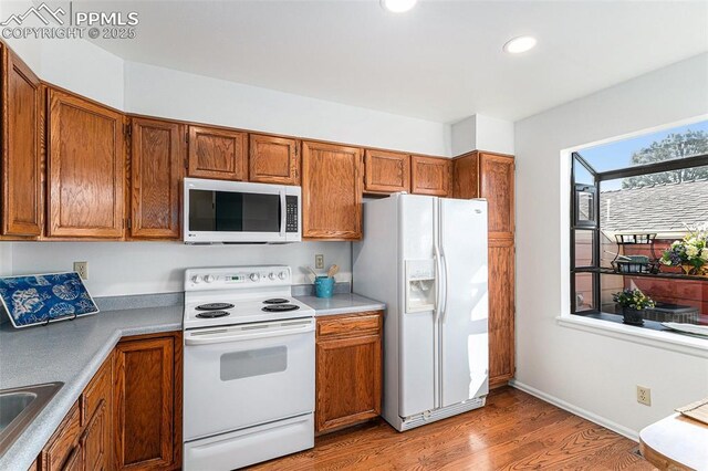 480 W Rockrimmon Blvd Unit D, Colorado Springs, CO 80919 - kitchen with white appliances, light wood finished floors, brown cabinetry, and recessed lighting