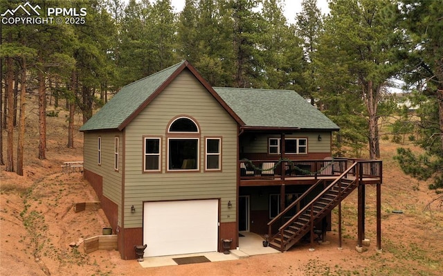 74 Buckskin Cir, Florissant, CO 80816 - chalet / cabin featuring a garage, a shingled roof, a wooden deck, stairs, and view of wooded area