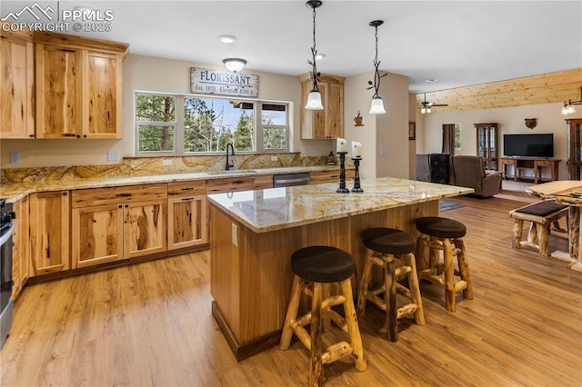 74 Buckskin Cir, Florissant, CO 80816 - kitchen featuring a sink, light wood finished floors, open floor plan, a breakfast bar area, and a center island