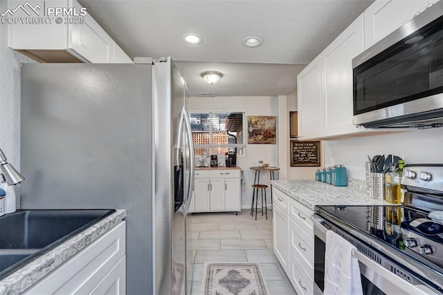 111 N 14th St, Colorado Springs, CO 80904 - kitchen with appliances with stainless steel finishes, white cabinetry, a sink, and recessed lighting