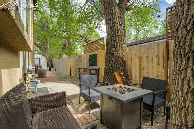 111 N 14th St, Colorado Springs, CO 80904 - view of patio / terrace with an outdoor fire pit, a fenced backyard, a shed, and an outbuilding