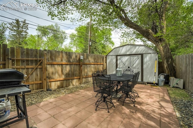 111 N 14th St, Colorado Springs, CO 80904 - view of patio featuring a storage shed, outdoor dining area, a fenced backyard, an outbuilding, and area for grilling