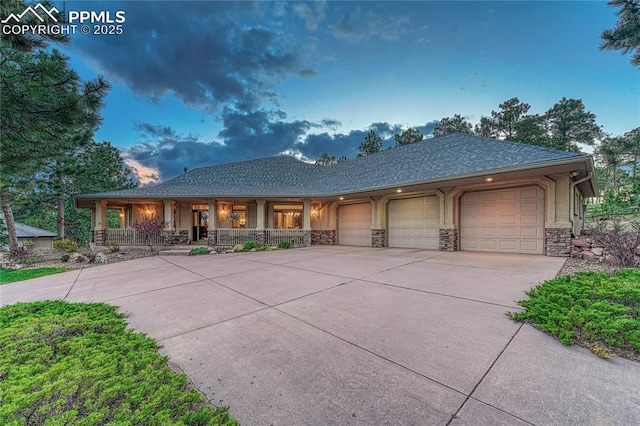 16150 Cliffrock Ct, Colorado Springs, CO 80921 - view of front of property featuring a porch, a garage, concrete driveway, stone siding, and roof with shingles