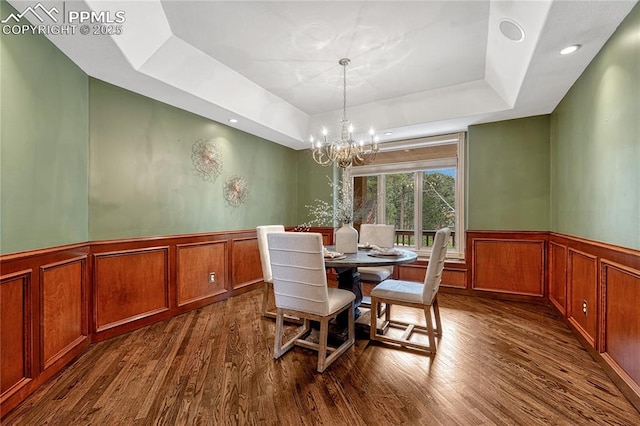 16150 Cliffrock Ct, Colorado Springs, CO 80921 - dining room with a wainscoted wall, a raised ceiling, dark wood-style flooring, a chandelier, and a decorative wall