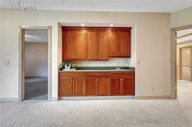 16150 Cliffrock Ct, Colorado Springs, CO 80921 - kitchen featuring light carpet, a sink, baseboards, and brown cabinets