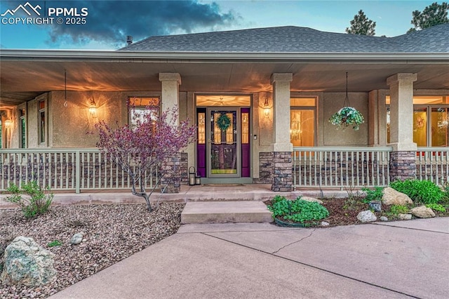 16150 Cliffrock Ct, Colorado Springs, CO 80921 - view of exterior entry with covered porch, a shingled roof, and stucco siding