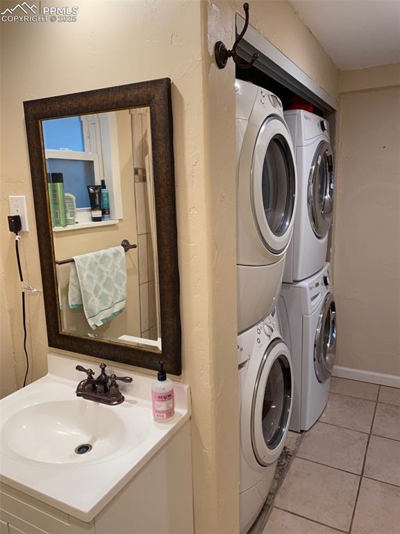 1304 Mount View Ln, Colorado Springs, CO 80907 - laundry room with stacked washing machine and dryer and light tile patterned floors
