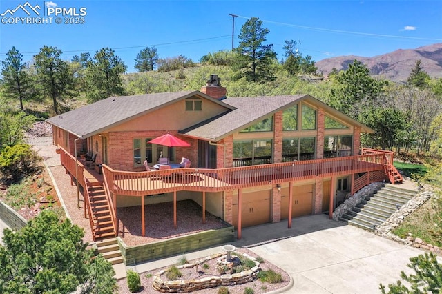 8020 Westwood Rd, Colorado Springs, CO 80919 - view of front of home featuring stairway, brick siding, a deck with mountain view, and concrete driveway
