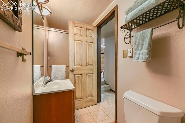 8020 Westwood Rd, Colorado Springs, CO 80919 - full bathroom featuring toilet, a stall shower, vanity, tile patterned floors, and a textured wall