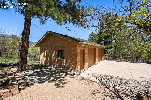 8020 Westwood Rd, Colorado Springs, CO 80919 - view of side of home with brick siding, fence, an outbuilding, and driveway