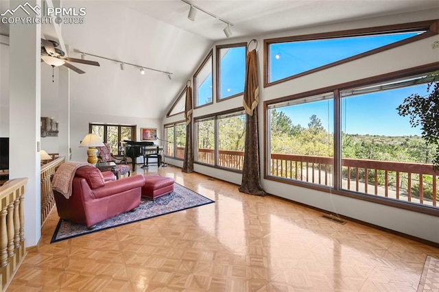8020 Westwood Rd, Colorado Springs, CO 80919 - living room featuring rail lighting, baseboards, ceiling fan, and high vaulted ceiling