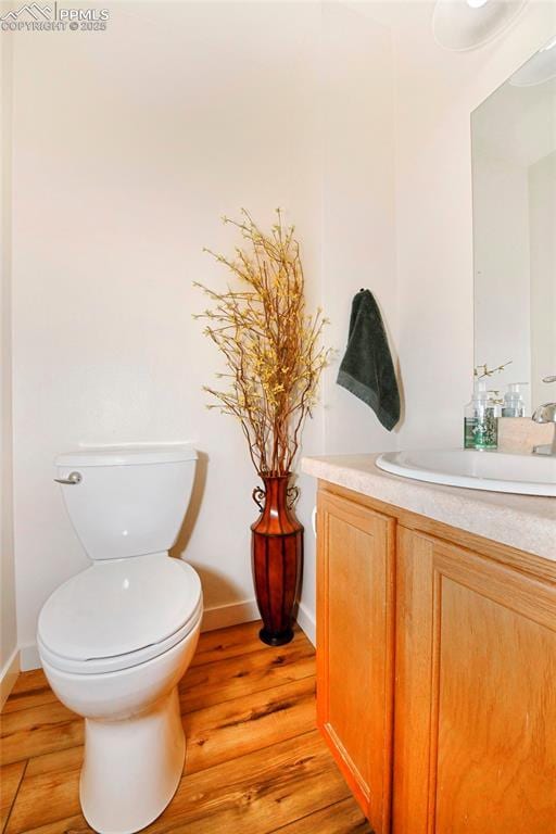 1234 Soaring Eagle Dr, Colorado Springs, CO 80915 - half bath with vanity, wood finished floors, toilet, and baseboards