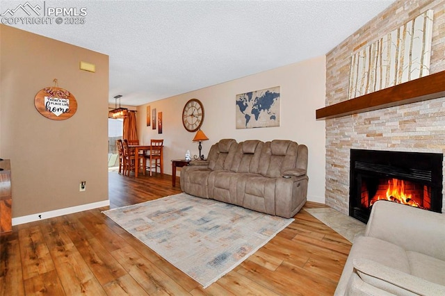 1234 Soaring Eagle Dr, Colorado Springs, CO 80915 - living area featuring hardwood / wood-style flooring, a fireplace with flush hearth, a textured ceiling, and baseboards