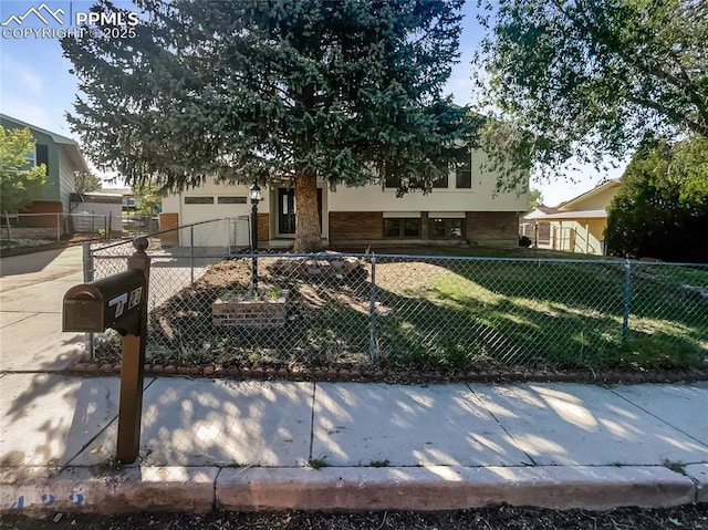 view of front of home featuring an attached garage, a fenced front yard, driveway, brick siding, and stucco siding