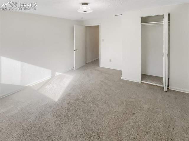 unfurnished bedroom with carpet flooring, a closet, and baseboards