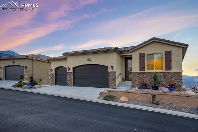 2062 Lone Willow Vw, Colorado Springs, CO 80904 - view of front of home featuring stone siding, stucco siding, a garage, and driveway