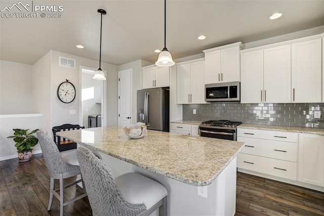 2062 Lone Willow Vw, Colorado Springs, CO 80904 - kitchen featuring appliances with stainless steel finishes, recessed lighting, a center island, dark wood-style flooring, and white cabinets
