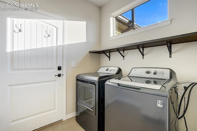 2062 Lone Willow Vw, Colorado Springs, CO 80904 - laundry area featuring washing machine and dryer, light tile patterned floors, and baseboards