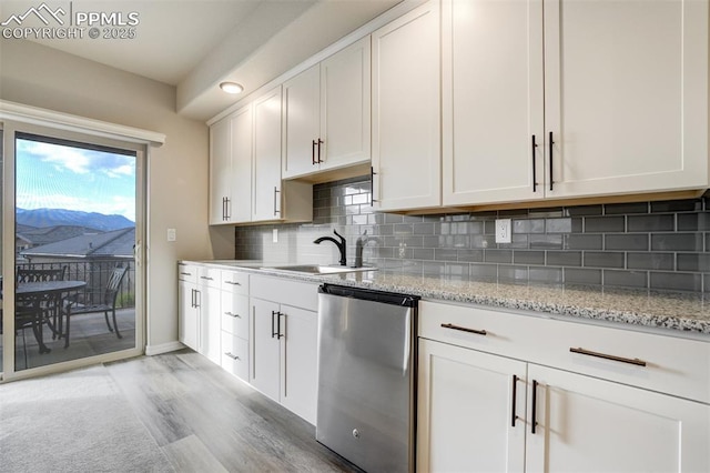 2062 Lone Willow Vw, Colorado Springs, CO 80904 - kitchen featuring dishwasher, a sink, light wood-type flooring, decorative backsplash, and light stone countertops